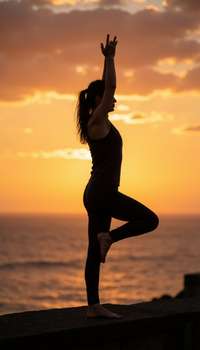 Artistic silhouette in yoga pose on beach or cliff at sunset, athletic figure visible through pose, 
